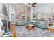 Open-concept living room featuring hardwood floors, elegant staircase, and seamless flow to the kitchen area at 3601 Tartancroft Pl, Fuquay Varina, NC 27526