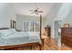 Bright main bedroom features a four-poster bed, hardwood floors, vaulted ceiling and ensuite bathroom at 3601 Tartancroft Pl, Fuquay Varina, NC 27526