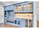 Stylish blue bar area featuring glass-front cabinets, wine storage, beverage refrigerator, and tiled backsplash at 390 Lake Magnolia Way, Smithfield, NC 27577