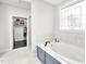 Bright bathroom featuring a soaking tub with window, vanity, and access to the closet at 390 Lake Magnolia Way, Smithfield, NC 27577