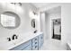 Bright bathroom with dual sinks, round mirrors, blue vanity, and plenty of storage at 390 Lake Magnolia Way, Smithfield, NC 27577