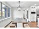 Dining room showcasing rustic wood table, modern light fixture, and ample natural light from large windows at 390 Lake Magnolia Way, Smithfield, NC 27577