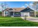 Charming home featuring a stone facade, covered porch, well-manicured lawn, and attached two-car garage at 390 Lake Magnolia Way, Smithfield, NC 27577