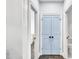 Hallway with light blue double doors, white trim, and hardwood floors leading to the bathroom and office at 390 Lake Magnolia Way, Smithfield, NC 27577