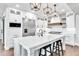 Modern white kitchen with a large island, stainless steel appliances, and pendant lighting at 390 Lake Magnolia Way, Smithfield, NC 27577