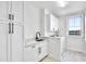 Functional laundry room with white cabinets, granite countertops, sink, and a front-load washer and dryer at 390 Lake Magnolia Way, Smithfield, NC 27577