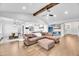 Open-concept living space with a large brown sectional, wood floors, and views into the kitchen and dining area at 390 Lake Magnolia Way, Smithfield, NC 27577