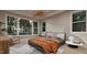Bright bedroom featuring a wooden ceiling fixture, an orange comforter, and large windows at 3908 Cedar Knolls Dr, Youngsville, NC 27596