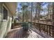 View of the home's deck featuring a table and chairs, set among the trees in the wooded backyard at 4815 Fortunes Ridge Dr, Durham, NC 27713