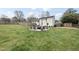 Large backyard shows a well-maintained lawn and a stone patio with seating, ideal for relaxation and outdoor entertainment at 4900 Skidmore St, Raleigh, NC 27609