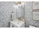 Chic bathroom features patterned wallpaper, elegant lighting, and a stylish vanity with gold hardware at 4900 Skidmore St, Raleigh, NC 27609