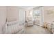 Cozy Bedroom featuring a white crib, comfortable chair, and soft, neutral tones at 4900 Skidmore St, Raleigh, NC 27609