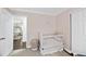 Charming Bedroom featuring a white crib, neutral rug, and stylish decor, creating a cozy and inviting space at 4900 Skidmore St, Raleigh, NC 27609
