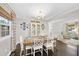Bright dining room featuring a wooden table, stylish white chairs, and decorative wall plates at 4900 Skidmore St, Raleigh, NC 27609
