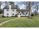 Charming two-story home featuring a brick chimney, a welcoming porch, and well-manicured landscaping at 4900 Skidmore St, Raleigh, NC 27609