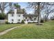 Charming two-story home featuring a brick chimney, a welcoming porch, and well-manicured landscaping at 4900 Skidmore St, Raleigh, NC 27609