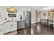 Open kitchen featuring white cabinets, stainless steel appliances, and a hardwood floor at 4900 Skidmore St, Raleigh, NC 27609