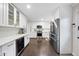 Bright kitchen with white cabinetry, subway tile backsplash, stainless steel appliances, and hardwood floors at 4900 Skidmore St, Raleigh, NC 27609