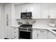 Stylish kitchen with white cabinets, stainless steel appliances, and sleek quartz countertops at 4900 Skidmore St, Raleigh, NC 27609