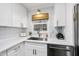 Well-designed kitchen featuring white cabinets, quartz countertops, and a stainless steel sink at 4900 Skidmore St, Raleigh, NC 27609
