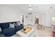 Comfortable living room featuring a sectional sofa, ottoman, and convenient access to the staircase and laundry room at 4900 Skidmore St, Raleigh, NC 27609