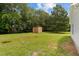 Backyard shed surrounded by luscious green grass and trees at 501 E Granville St, Dunn, NC 28334