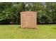Wooden shed in a backyard with green grass and surrounding trees at 501 E Granville St, Dunn, NC 28334