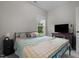 Cozy bedroom featuring a metal frame bed, window, and TV on a wooden table at 501 E Granville St, Dunn, NC 28334