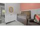 A calming Bedroom features a dresser, changing table, a crib and a comfortable armchair at 501 E Granville St, Dunn, NC 28334