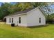 Rear view of a white home featuring green grass, and an A/C unit at 501 E Granville St, Dunn, NC 28334