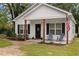 Close up, inviting front view of a cozy white home featuring a charming 'Welcome' door sign at 501 E Granville St, Dunn, NC 28334