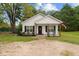 Inviting front view of a cozy white home with a landscaped yard and welcoming porch at 501 E Granville St, Dunn, NC 28334