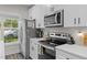 A modern kitchen features stainless steel appliances, white cabinets with black hardware, and wood-look flooring at 501 E Granville St, Dunn, NC 28334