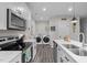 Bright kitchen featuring stainless steel appliances, white cabinets, island, and laundry area at 501 E Granville St, Dunn, NC 28334