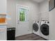 A well-equipped laundry room with front-loading washer/dryer and a door to the outside at 501 E Granville St, Dunn, NC 28334