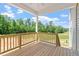 A cozy covered porch that features wood flooring and railing that overlooks the backyard at 55 Cordoba Dr, Franklinton, NC 27525