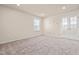 Spacious carpeted bedroom with natural light streaming through a window and white double doors at 5800 Agrinio Way, Raleigh, NC 27603