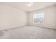 Bright bedroom featuring neutral walls, carpeted floor, and a window offering neighborhood views at 5800 Agrinio Way, Raleigh, NC 27603