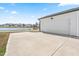 Rear of home featuring a detached garage with concrete parking pad and a view of the pond at 5800 Agrinio Way, Raleigh, NC 27603