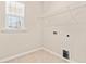 Functional laundry room with tiled floor, window, wire rack, and essential hookups for appliances at 5800 Agrinio Way, Raleigh, NC 27603
