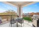 Outdoor seating with a small table and grill with wrought iron railing with a view of mature trees at 620 Wade Ave # 506, Raleigh, NC 27605