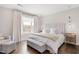 Cozy bedroom with a large window providing natural light, upholstered headboard, and hardwood floors at 620 Wade Ave # 506, Raleigh, NC 27605
