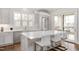 Bright kitchen features an island with white countertops and seating, stainless steel appliances, and modern lighting at 620 Wade Ave # 506, Raleigh, NC 27605