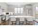 Spacious white kitchen with an island, stainless steel appliances, and view to the outdoor balcony at 620 Wade Ave # 506, Raleigh, NC 27605