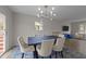 Open dining room with modern light fixture, large table, and view into adjacent living area is excellent for entertaining at 6216 Lewisand Cir, Raleigh, NC 27615