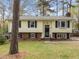 Charming yellow home with black shutters, brick accents, and a well-maintained front lawn at 6216 Lewisand Cir, Raleigh, NC 27615
