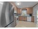 Well-lit kitchen with stainless steel refrigerator and wood cabinets is a functional, inviting space at 6216 Lewisand Cir, Raleigh, NC 27615