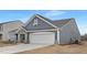 Contemporary single-Gathering home showcasing a two-car garage and stylish stone and siding exterior at 63 Mable Court # 6, Lillington, NC 27546