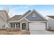Charming single Gathering home with stone accents, blue siding, and a welcoming two car garage at 63 Mable Court # 6, Lillington, NC 27546