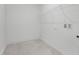 Bright laundry room with unique tile flooring, open shelving, and utility connections at 63 Mable Court # 6, Lillington, NC 27546